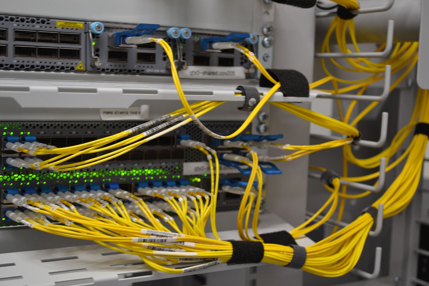 Single-mode fibre patched into core routing equipment in a data centre rack.